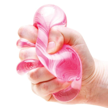 Hånd der klemmer NeeDoh Nice Cube Candy Swirl med røde og hvide hvirvler