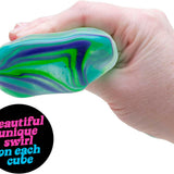 Hånd der klemmer en NeeDoh Nice Cube Swirl squishy