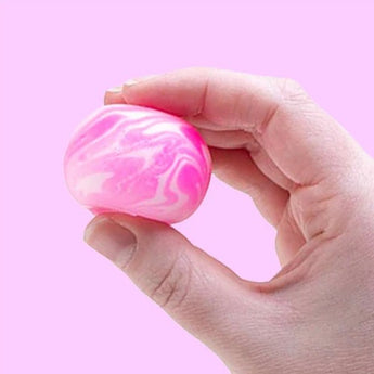 NeeDoh Teenie Swirl squishy i hvid og pink klemt i en hånd