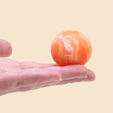 NeeDoh Teenie Swirl squishy i hvid og orange i en håndflade